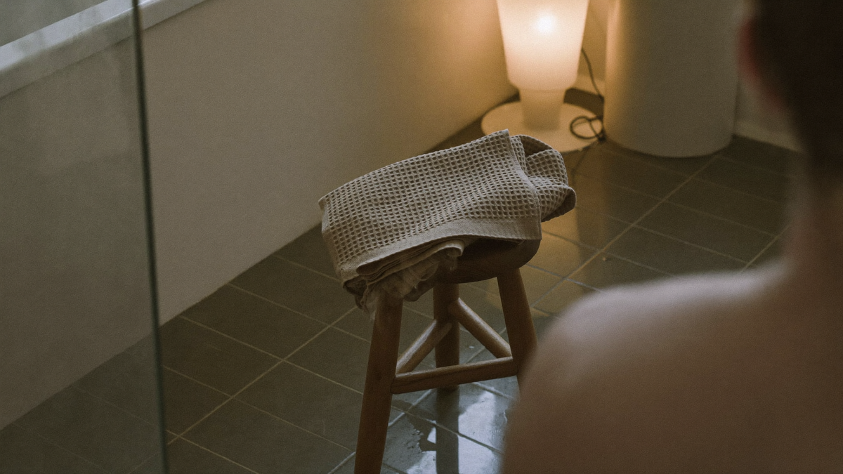 Roligt badeværelse om aftenen med foldet håndklæde og damp